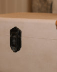 detailed shot of the metal clasp on linen storage trunks.