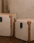 Set of two linen storage trunks on wooden floor.