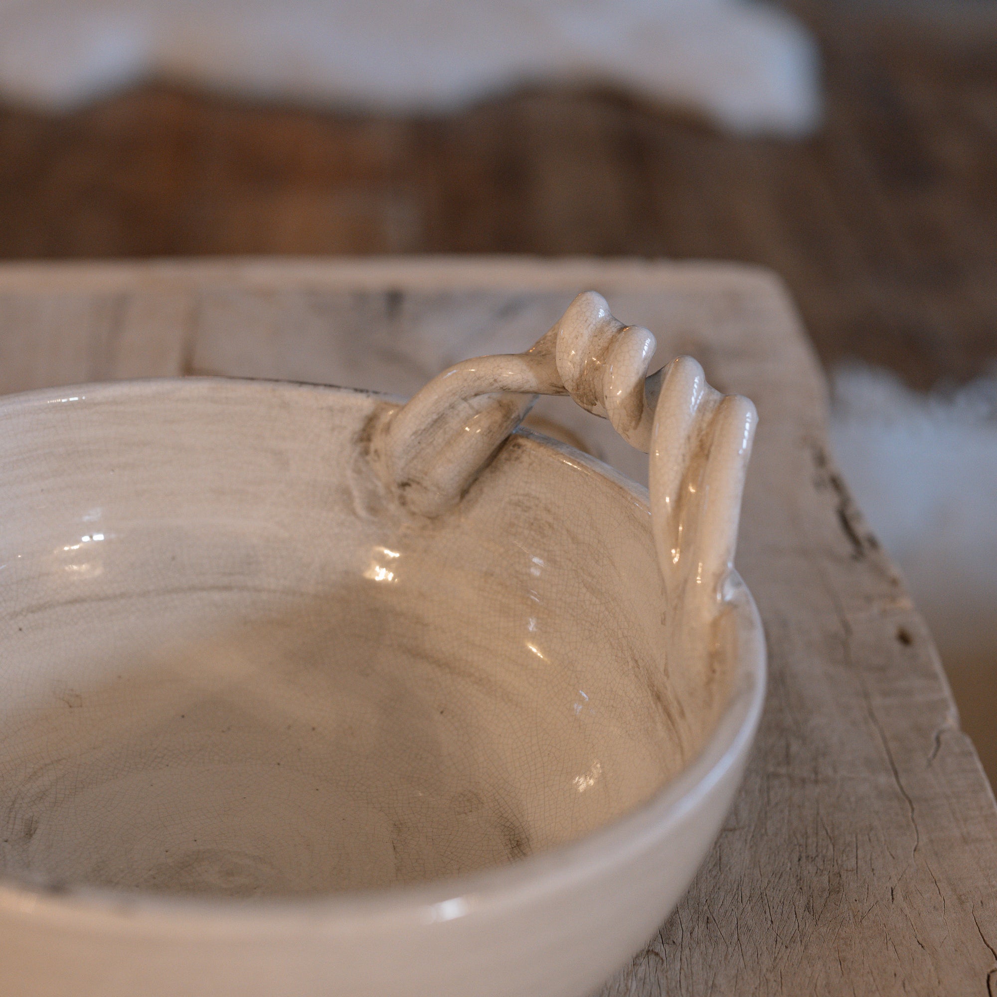 Detailed shot of white ceramic bowl with twisted handles. 