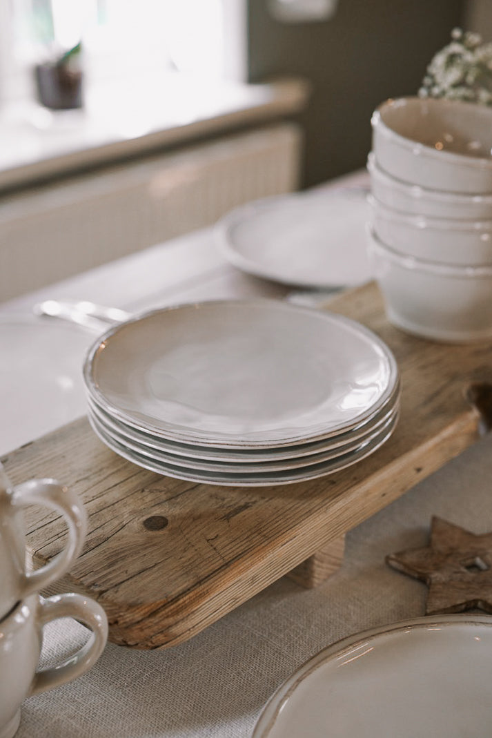 stack of ceramic plates on wooden table.